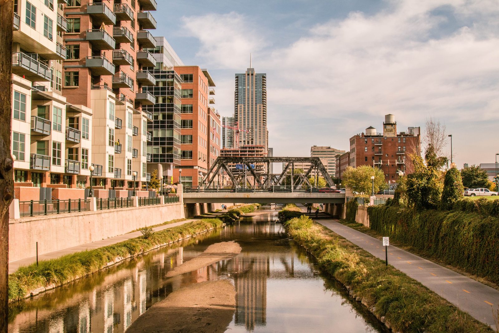 Apartment and office buildings along the Cherry Creek trail with the downtown Denver skyline