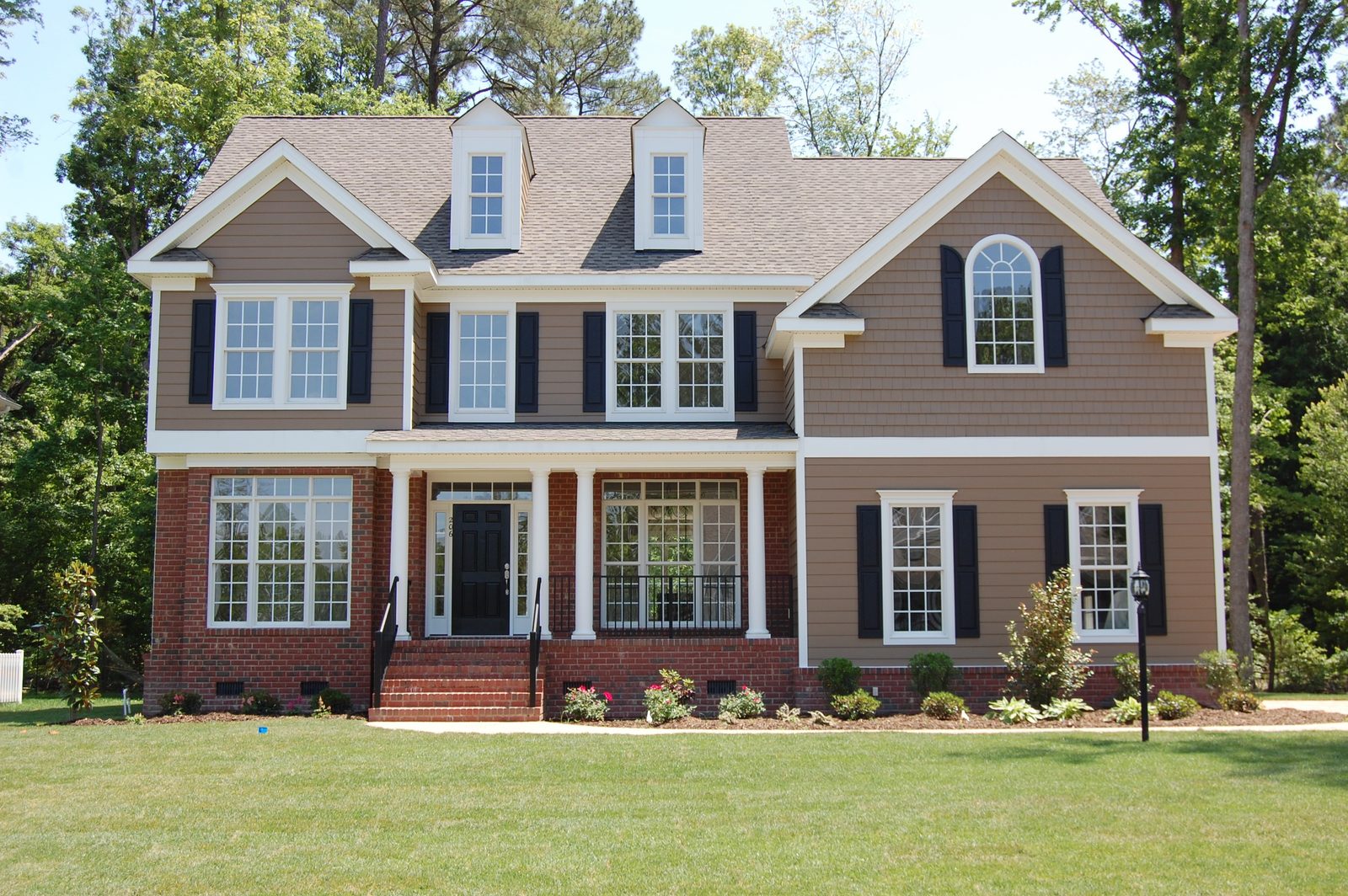Two-story home with brick and siding exterior and a covered front porch